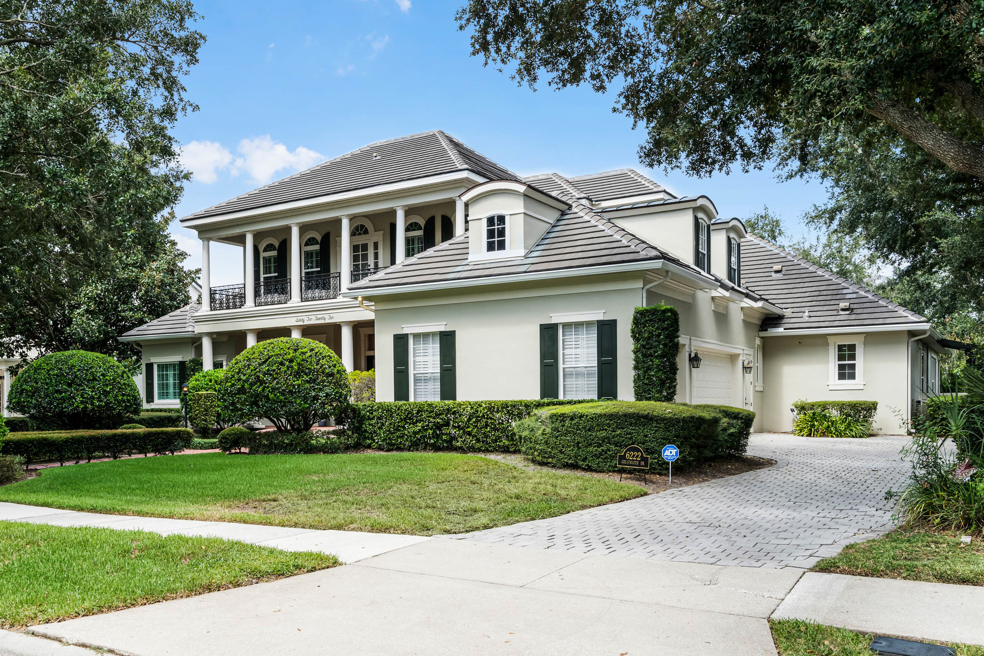 front of two story home with white paint and long driveway